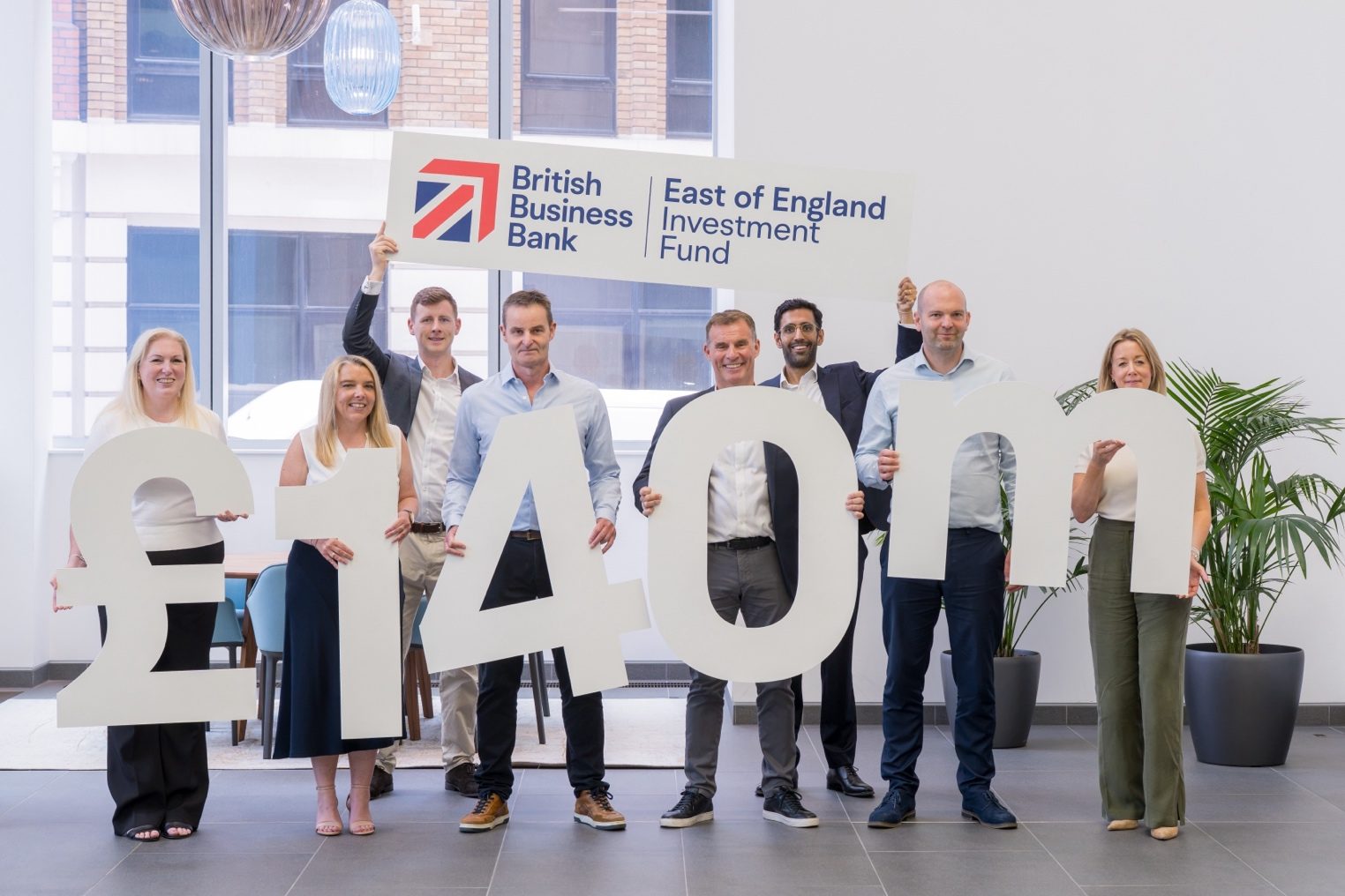 The Eastmeare and British Business Bank teams holding a £140m sign and an East of England Investment Fund banner